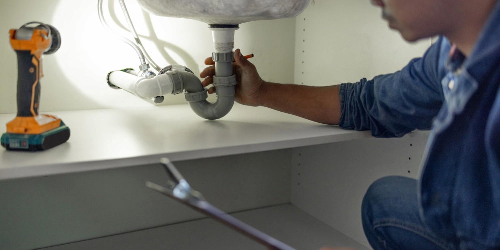 Plumber checking below the sink